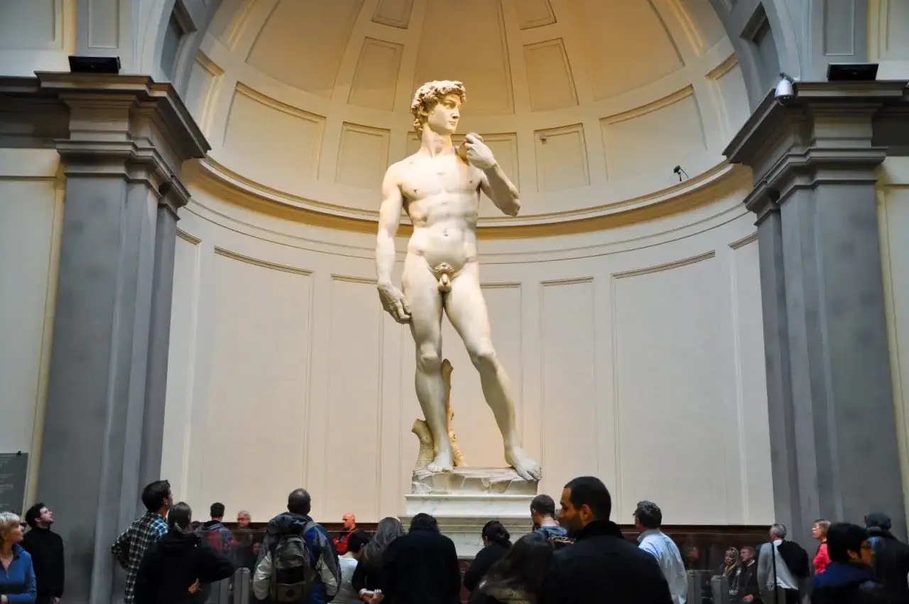 Il David di Michelangelo domina la sala della Galleria dell'Accademia, ammirato da visitatori che ne contemplano la perfezione.