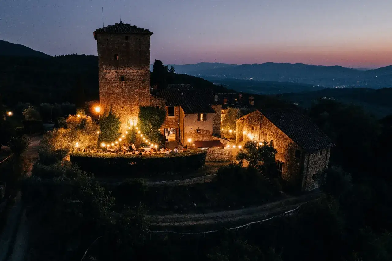 Borgo medievale illuminato da luci calde, scenario perfetto per un film in Toscana.
