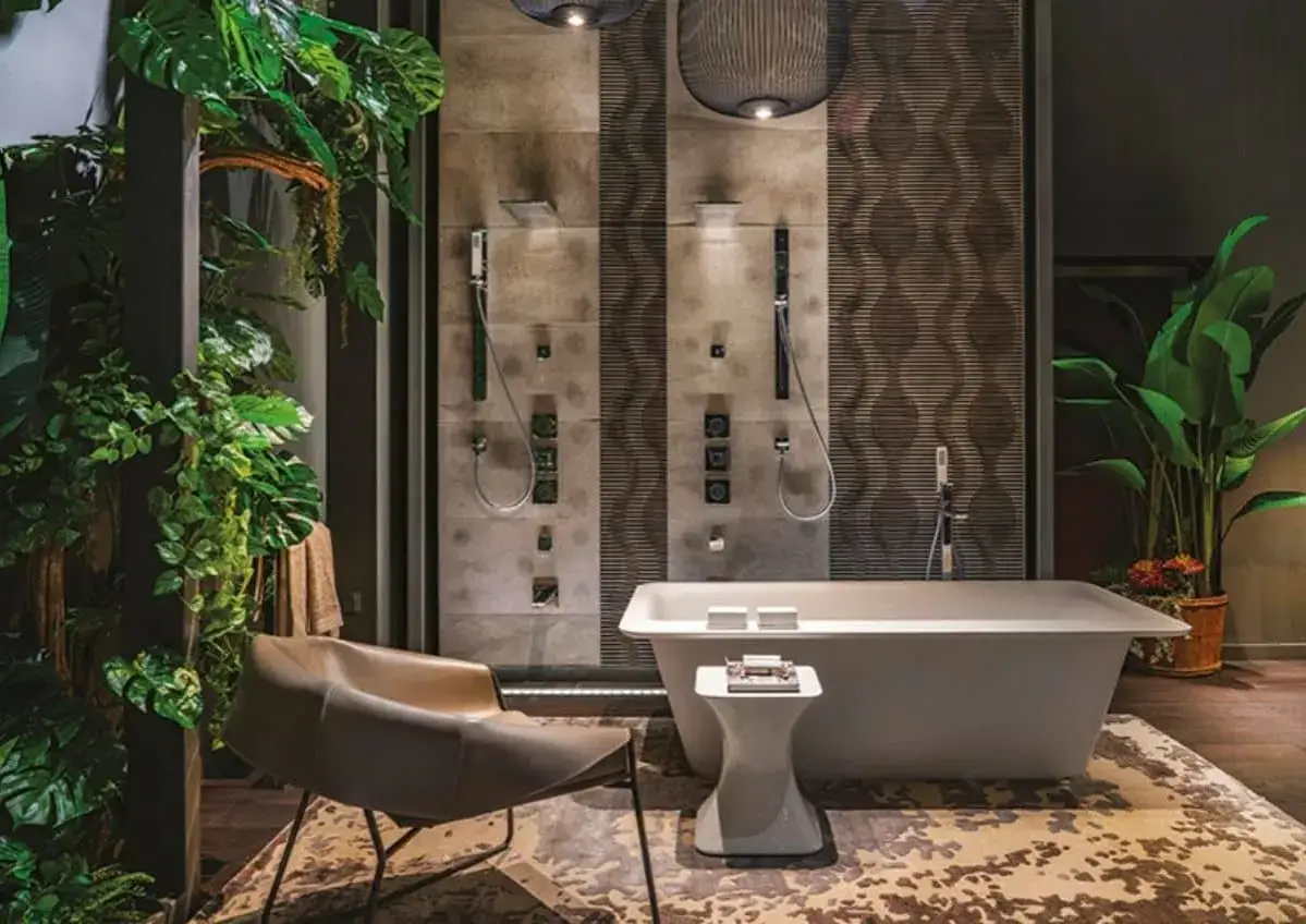 Salle de bain luxueuse avec baignoire &icirc;lot, double douche et v&eacute;g&eacute;tation luxuriante. Un fauteuil design invite &agrave; la d&eacute;tente dans ce wet room tropical.