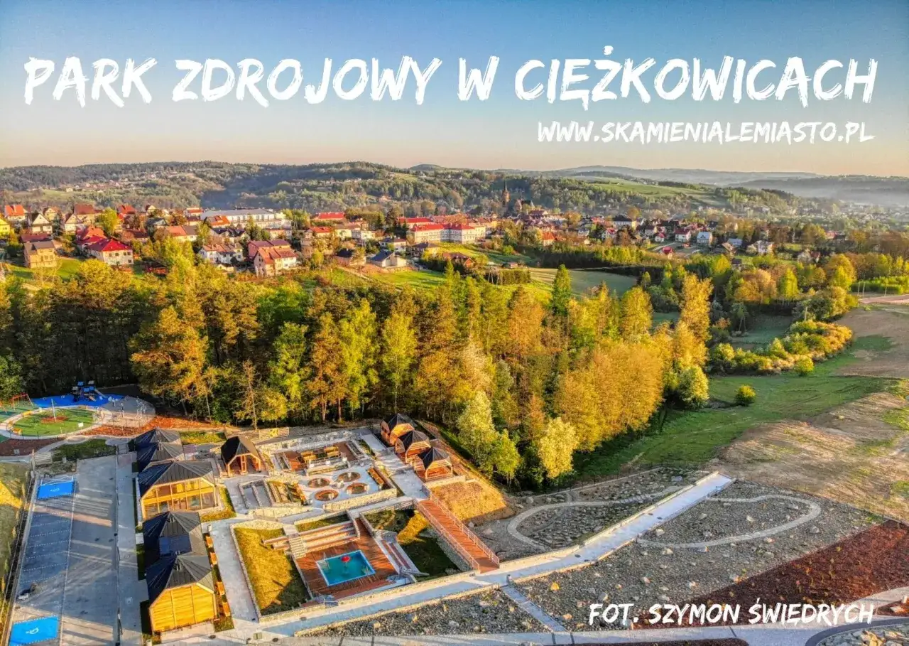 Widok z lotu ptaka na Park Zdrojowy w Ciężkowicach, z malowniczym kamiennym miastem, basenem i placem zabaw.