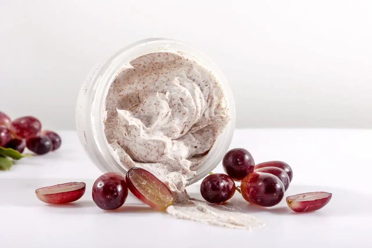 Vaso di scrub corpo con uva. Ideale per esfoliare e rinnovare la pelle, rivelando una nuova luminosità.