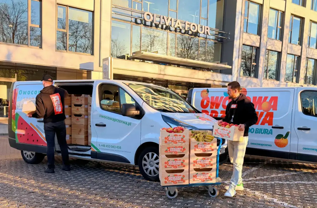 Pracownicy dostarczają skrzynki z owocami do biura. To z pewnością owocowe czwartki!