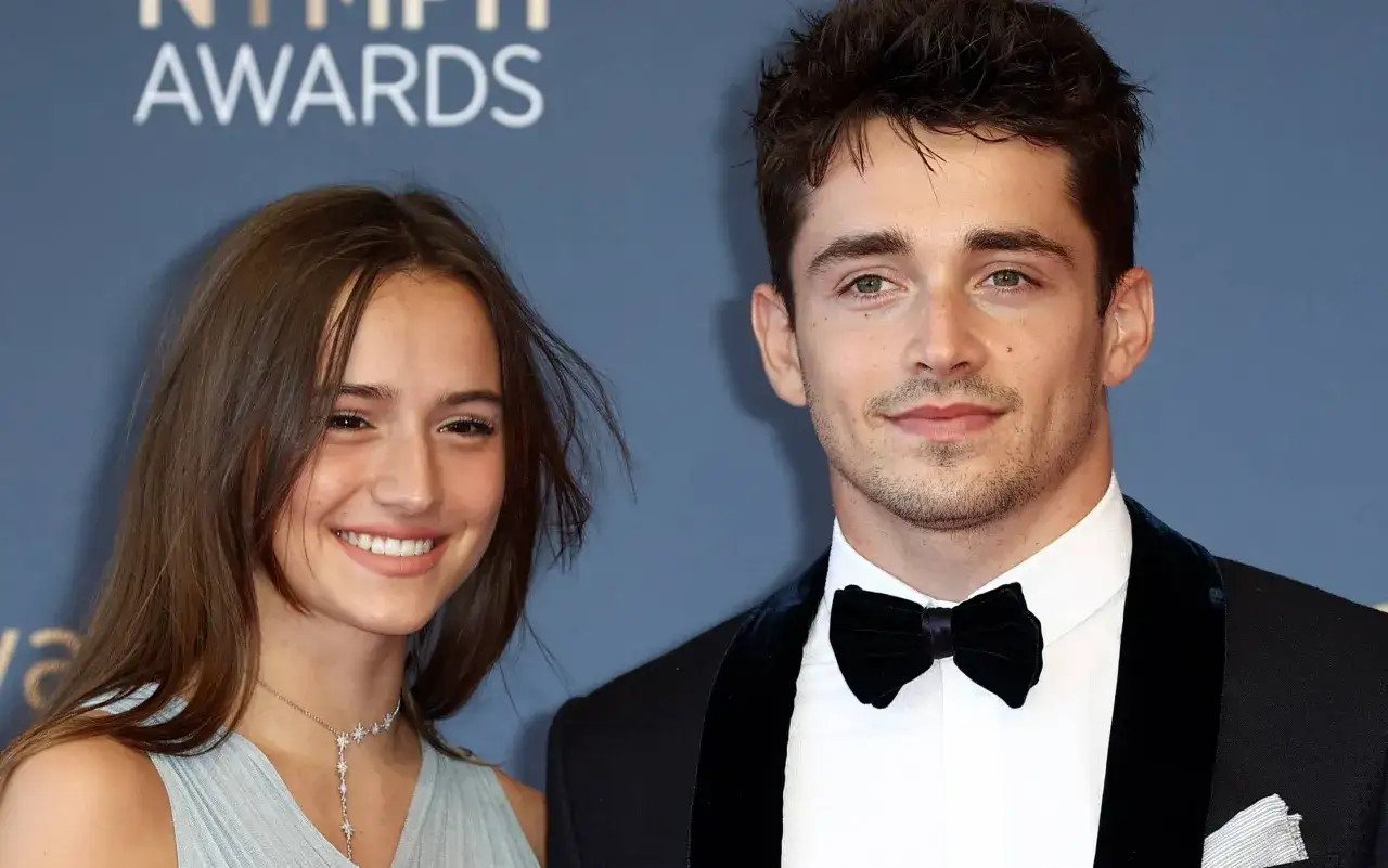 Charles Leclerc e la sua fidanzata sorridono sul red carpet.
