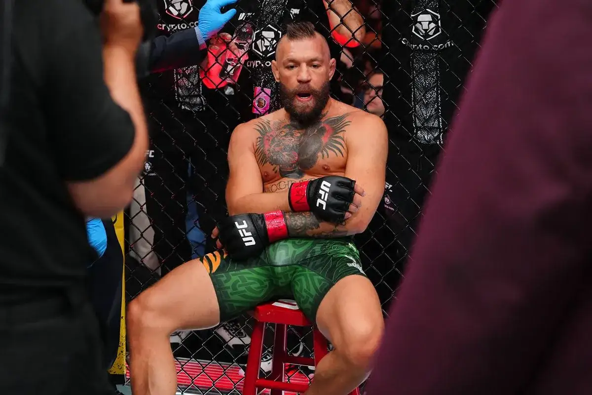 Conor McGregor sits in his corner, contemplating his next move. His expression hints at the complex tko retirement meaning for fighters.