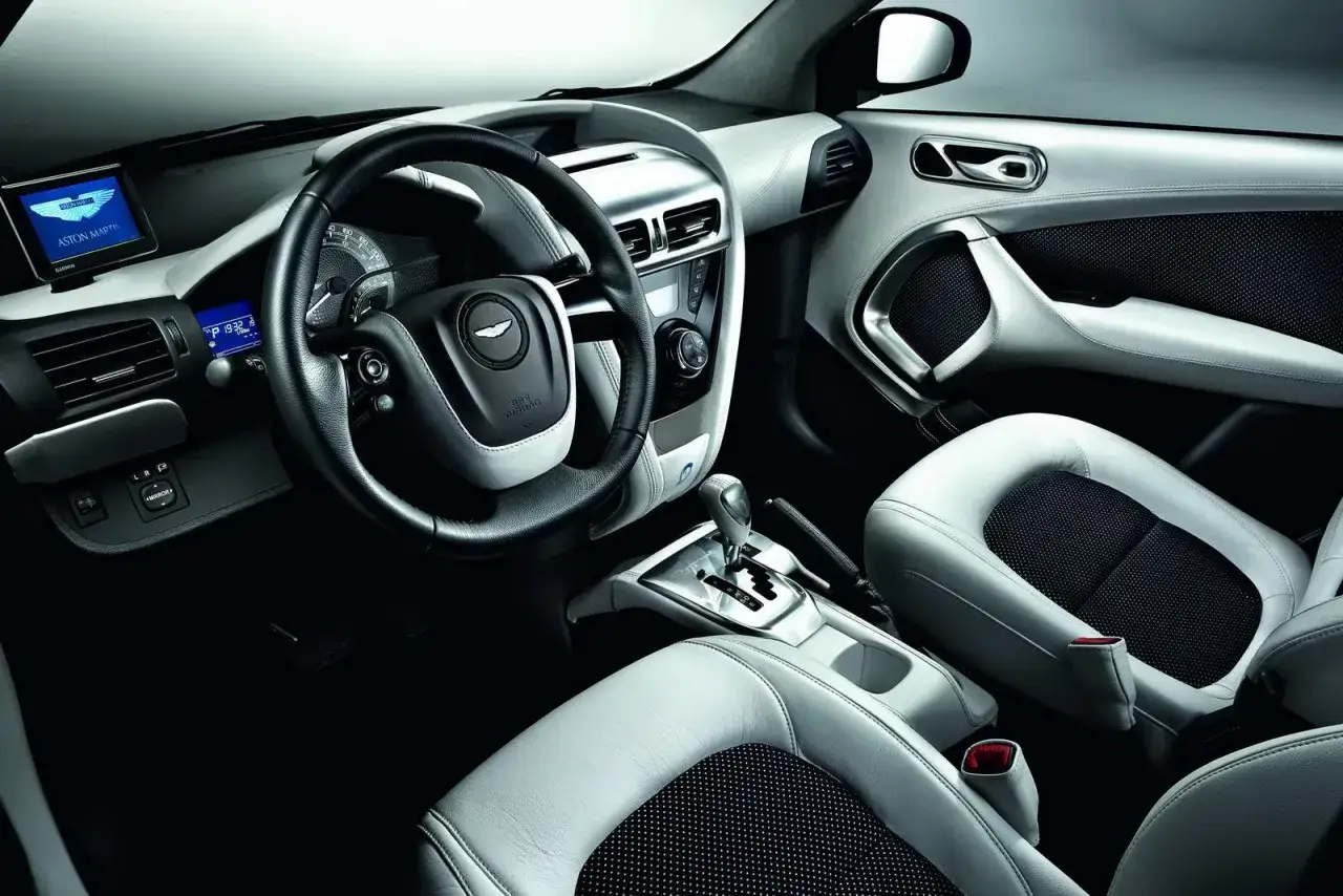 Wnętrze Aston Martin Cygnet: skórzana tapicerka, kierownica z logo, nawigacja Garmin i elegancka konsola środkowa.