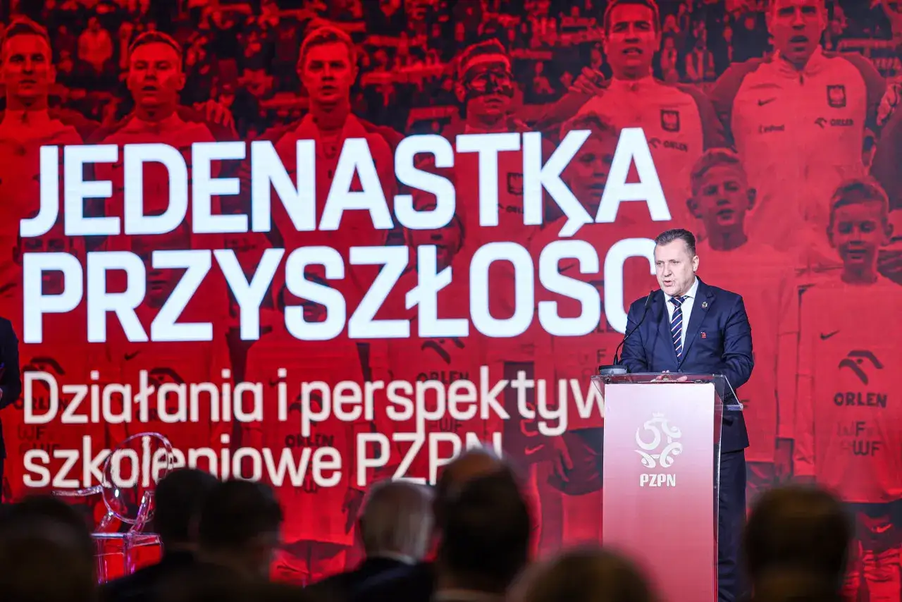 Prezes PZPN przemawia na tle hasła 