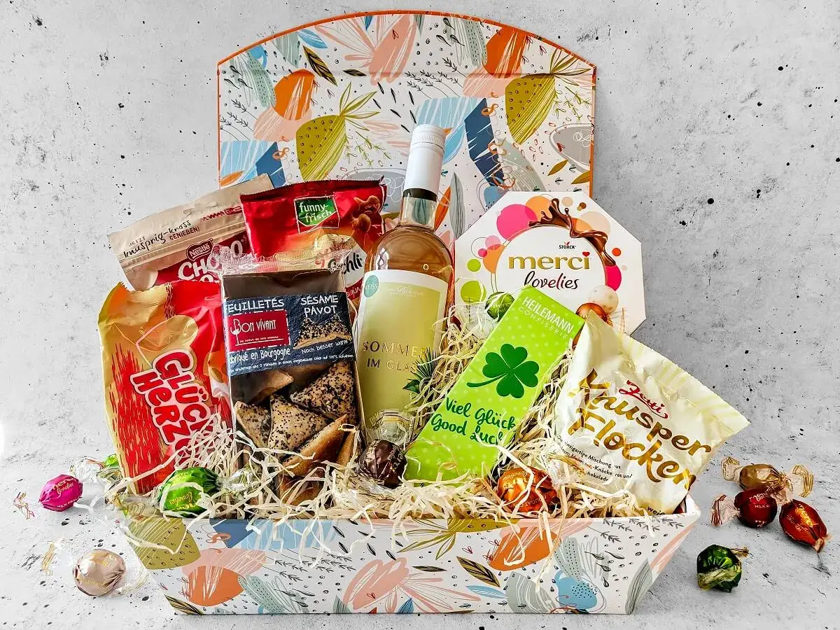 Bunte Geschenkkörbe zum Geburtstag mit Wein, Merci Lovelies, Keksen und Schokolade. Perfekt für jeden Anlass!