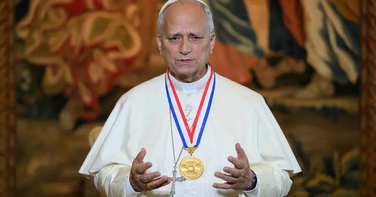 Papież w białej sutannie, z medalem na szyi, opowiada o tym, skąd pochodzi.