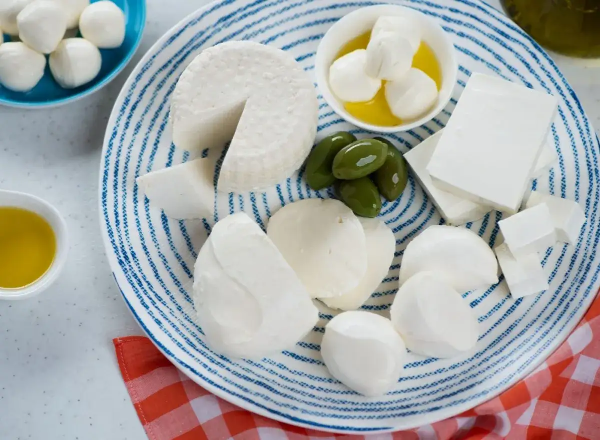 Assortimento di formaggi bianchi, tra cui feta e mozzarelline, con olive e olio d'oliva. Un piacere per il palato, ma attenzione al colesterolo!