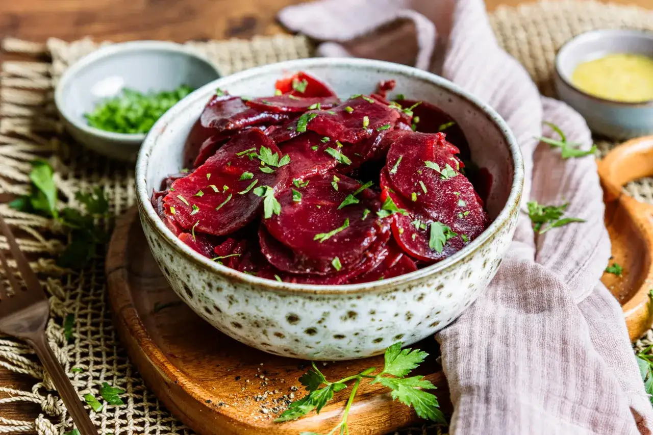 Schmackhafter rote Bete Salat nach Omas Art, mit frischer Petersilie garniert, serviert in einer rustikalen Sch&uuml;ssel.
