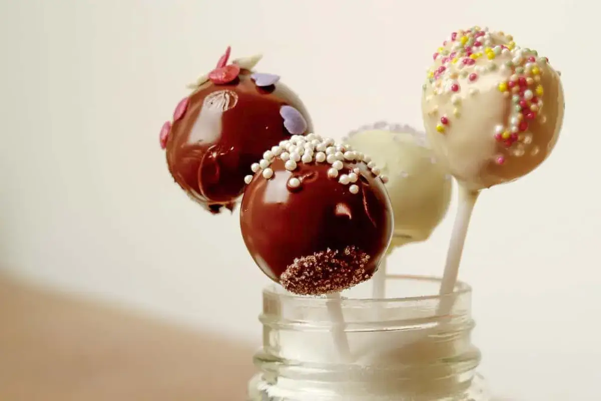 Leckere cake pops aus kuchenresten, verziert mit Schokolade und Streuseln, stehen in einem Glas.