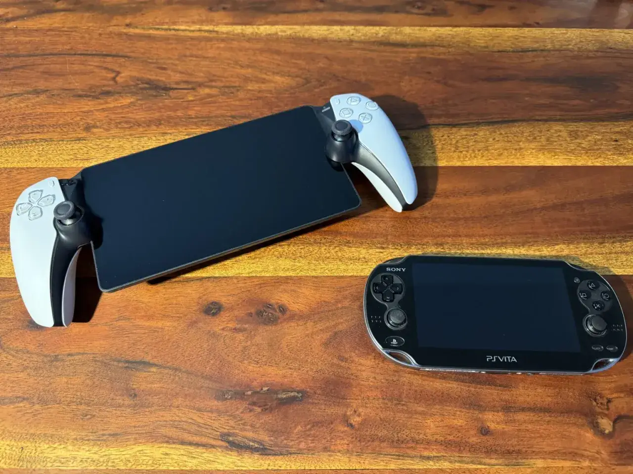 Nowe i stare handheldy Sony: nowoczesny uchwyt z kontrolerami DualSense do telefonu i klasyczna konsola PS Vita.