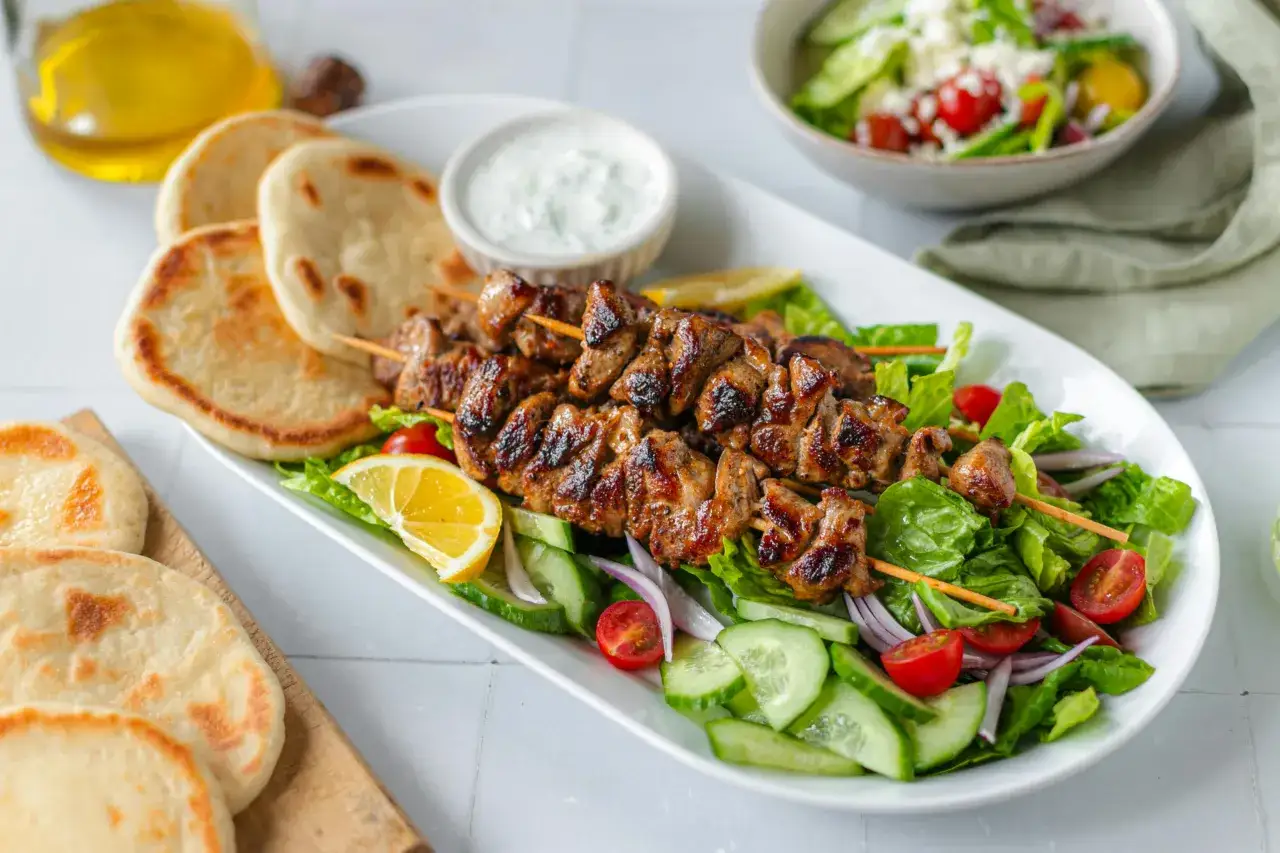 Saftiges Souvlaki vom Spie&szlig;, serviert mit Pitabrot, Tzatziki und frischem Salat. Ein authentisches Souvlaki Rezept original f&uuml;r den perfekten Genuss.