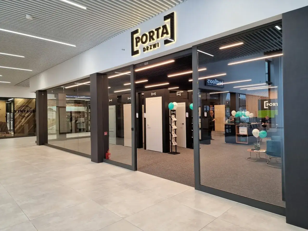 Salon drzwi z ekspozycją modeli i logo 