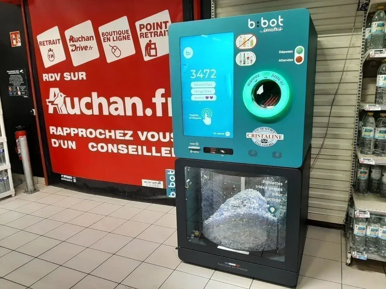 Un distributeur automatique b:bot montre comment recycler les bouteilles en plastique. Il compte les bouteilles et les transforme en paillettes pour le recyclage.