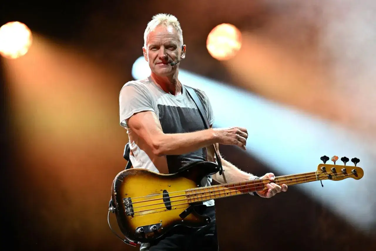 Sting gra na gitarze basowej podczas koncertu. Zapowiedź nadchodzących wydarzeń muzycznych.
