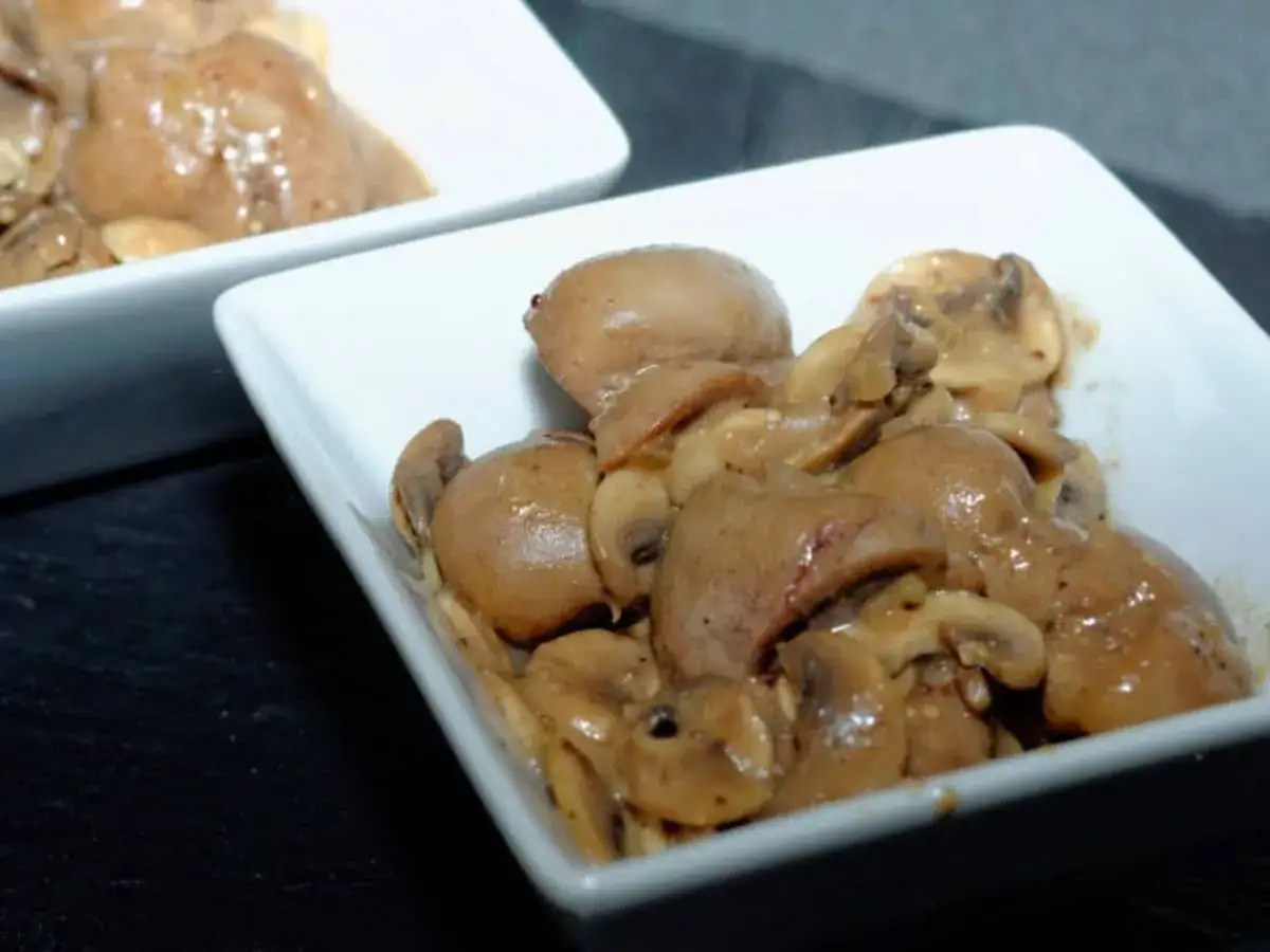 Deux bols blancs présentent une fricassée de rognons de veau et de champignons, nappée d'une sauce onctueuse.