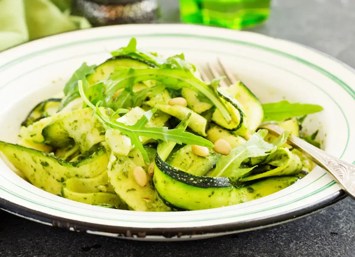 Sałatka z cukinii w sosie pesto, z rukolą i orzeszkami pinii. Czy cukinię się obiera? W tej potrawie nie, skórka dodaje koloru i tekstury.