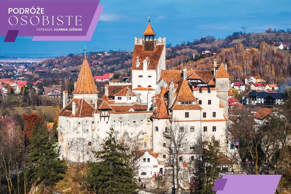 Malowniczy zamek w Transylwanii, otoczony jesiennymi wzgórzami i domkami.