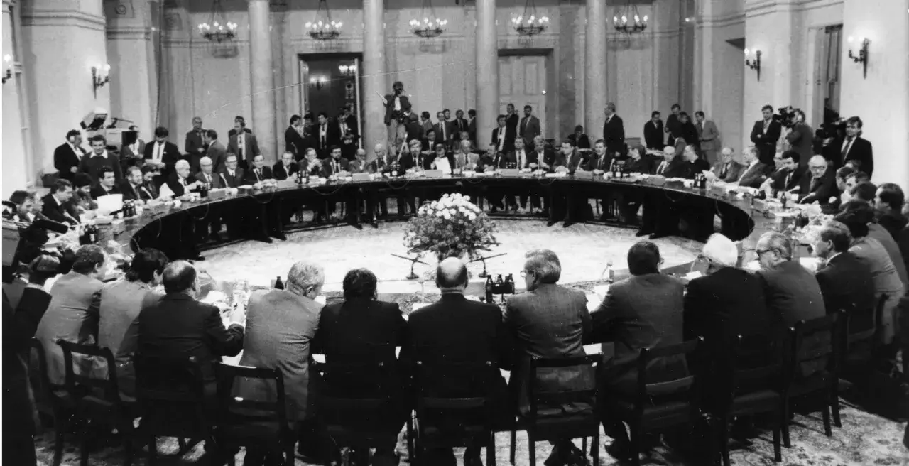 Okrągły stół, przy którym siedzą mężczyźni w garniturach. To historyczne spotkanie, które doprowadziło do powstania **3 Rzeczypospolitej**.