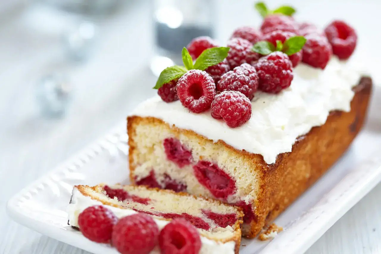 Un d&eacute;licieux g&acirc;teau framboise, garni de cr&egrave;me fouett&eacute;e et de framboises fra&icirc;ches, saupoudr&eacute; de sucre glace.
