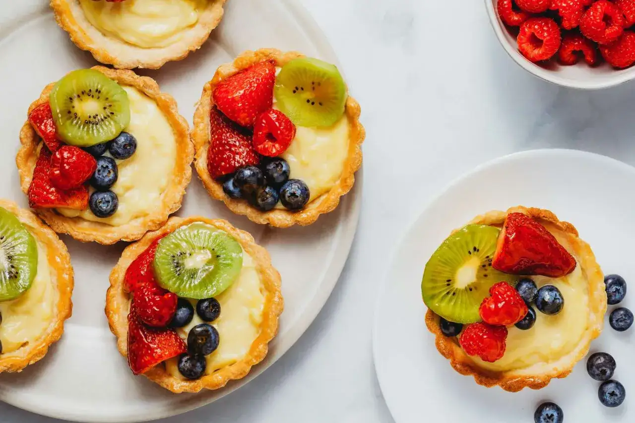 Petites tartes aux fruits frais sur une crème pâtissière onctueuse. Une recette parfaite pour une tarte fruitée.