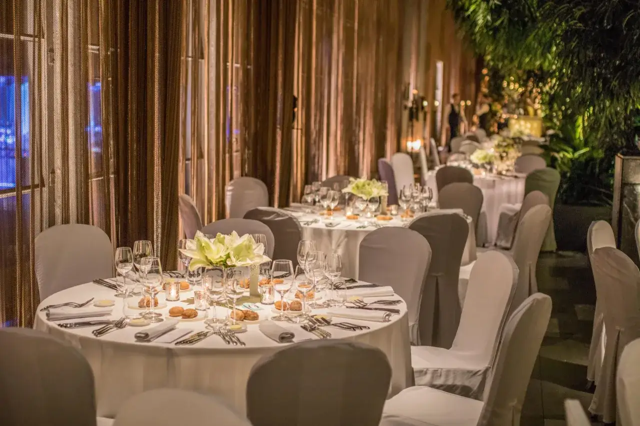 Eleganckie stoły z kwiatami i zastawą, przygotowane na wyjątkową kolację w najdroższej restauracji w Warszawie.