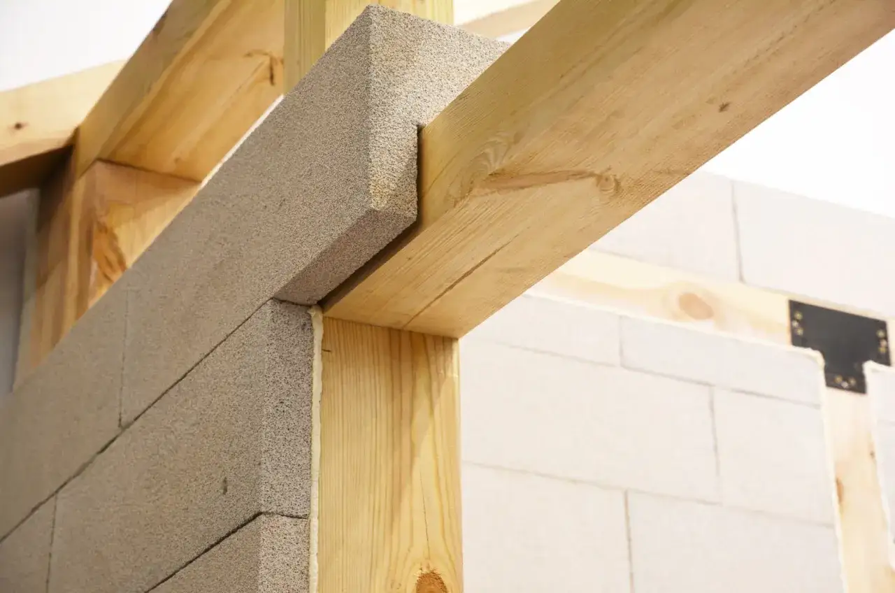 Drewniane nadproże nad drzwiami 90 cm, wsparte na bloczkach z betonu komórkowego.