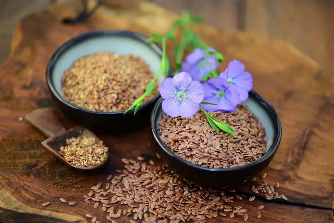Leinsamen, eine tolle Option für ei ersatz backen, mit zarten blauen Blüten auf rustikalem Holz.
