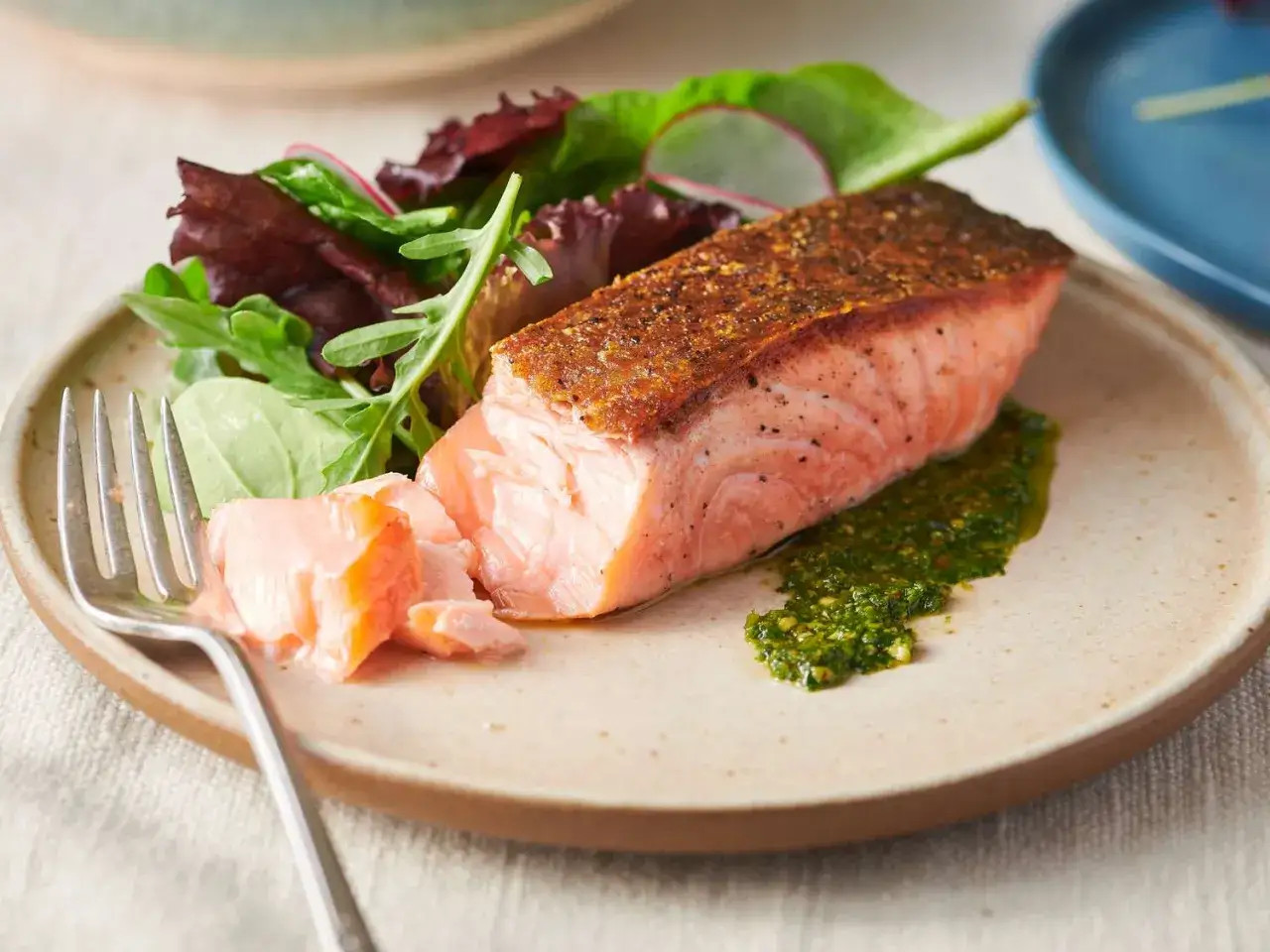 Perfekt gebratener Lachs mit knuspriger Kruste, serviert mit frischem Salat und Kräutersauce. Ein Genuss für alle Sinne!
