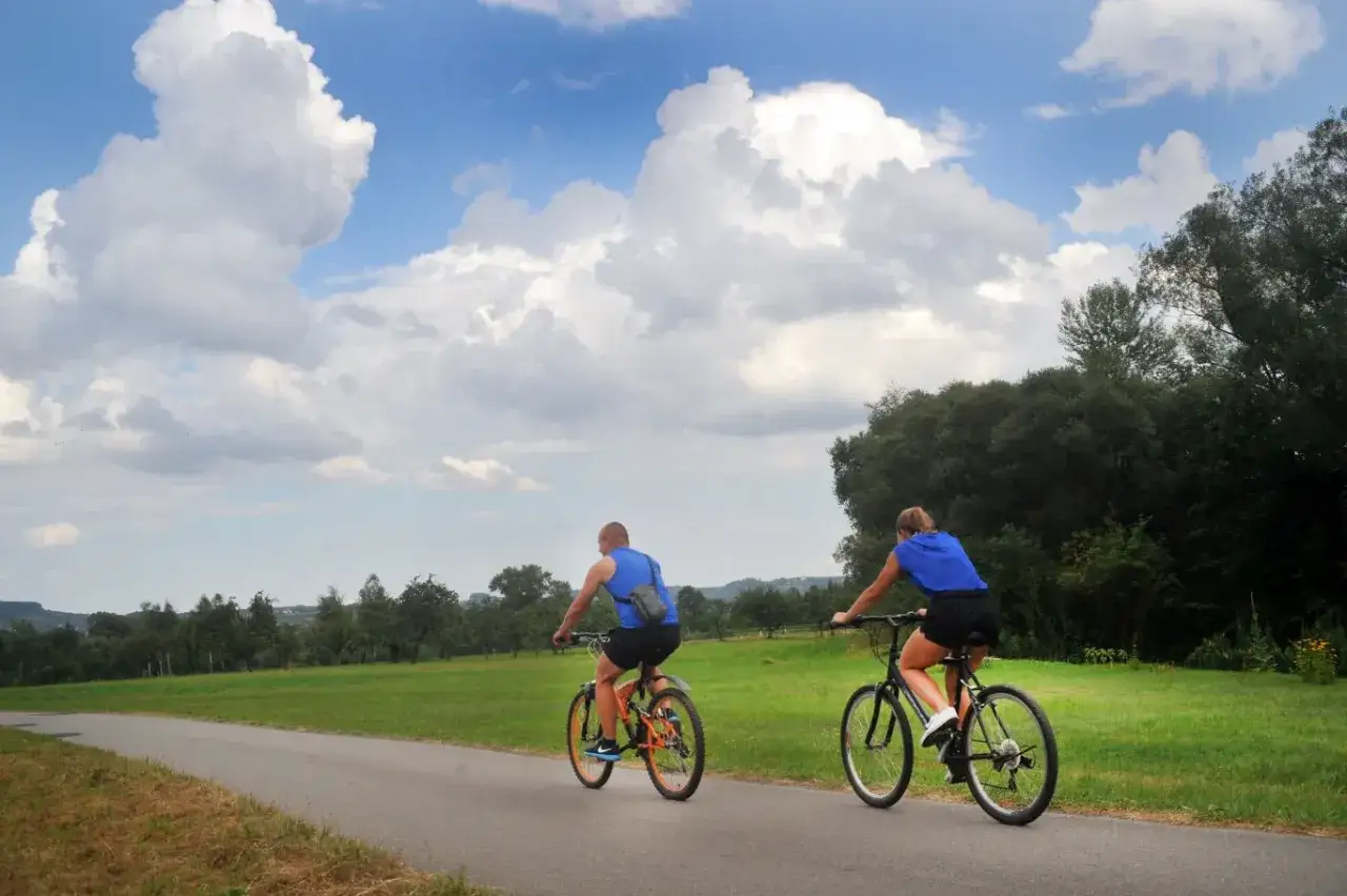 Para rowerzystów przemierza malowniczą ścieżkę, odkrywając jedne z najpiękniejszych tras rowerowych w Polsce.