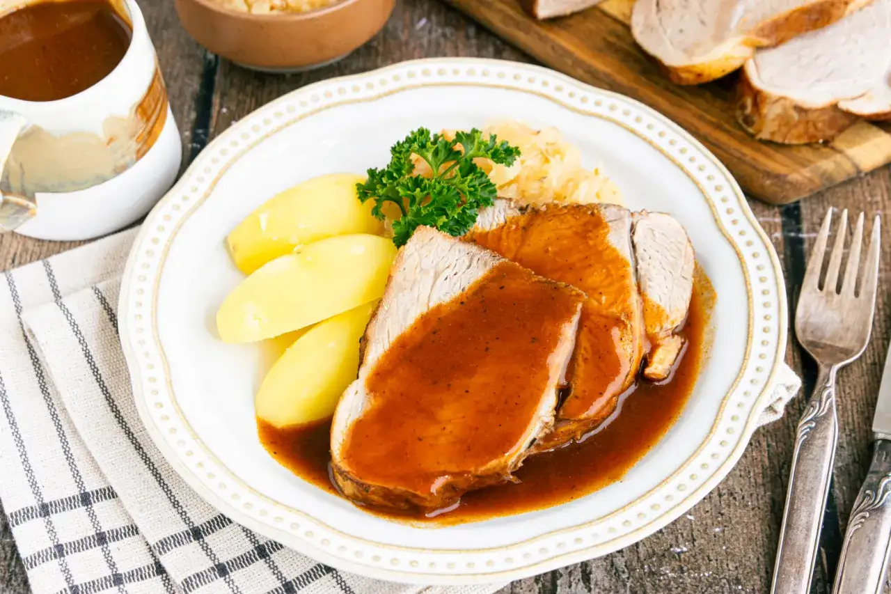 Saftiger Schweinebraten mit Kartoffeln und Sauerkraut, ein klassisches Schweinebraten Rezept.