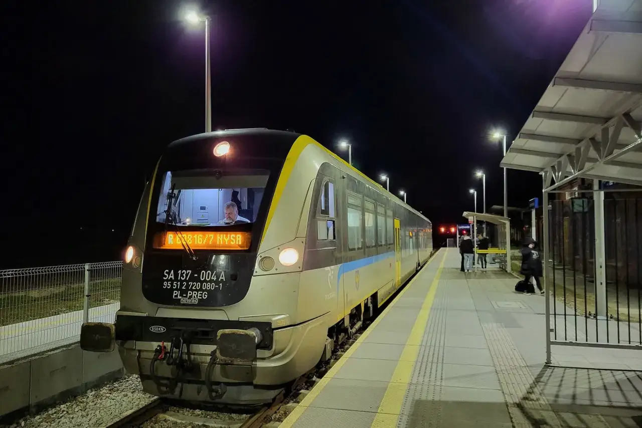 Pociąg PKP Nysa Wrocław stoi na nocnym peronie. Maszynista w kabinie.
