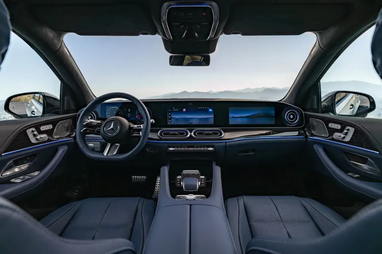 Wnętrze Mercedes GLE 2026: nowoczesne ekrany, skórzana tapicerka i ambientowe oświetlenie tworzą luksusową atmosferę podczas podróży.