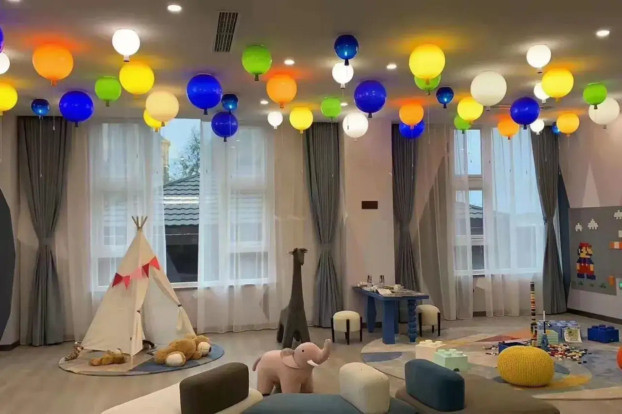 Kolorowa lampa balonik rozświetla pok&oacute;j dziecięcy, tworząc radosną atmosferę.