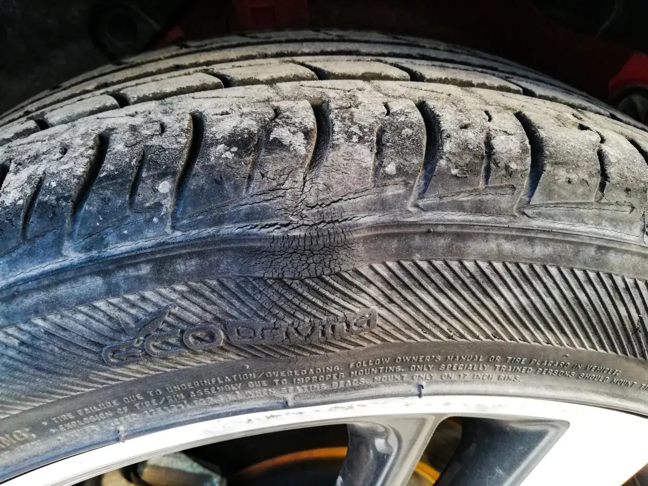 Gros plan sur un pneu de voiture présentant une hernie inquiétante. Combien de temps avant qu'il n'éclate ? À changer d'urgence.