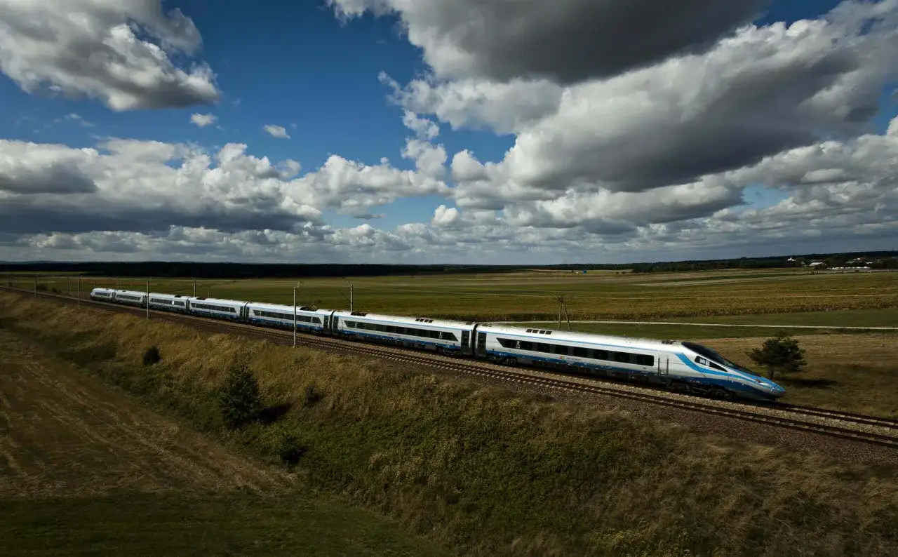 Szybki pociąg PKP Intercity mknie przez pola. Idealny na weekendowy wypad, gdy masz bilet weekendowy PKP.