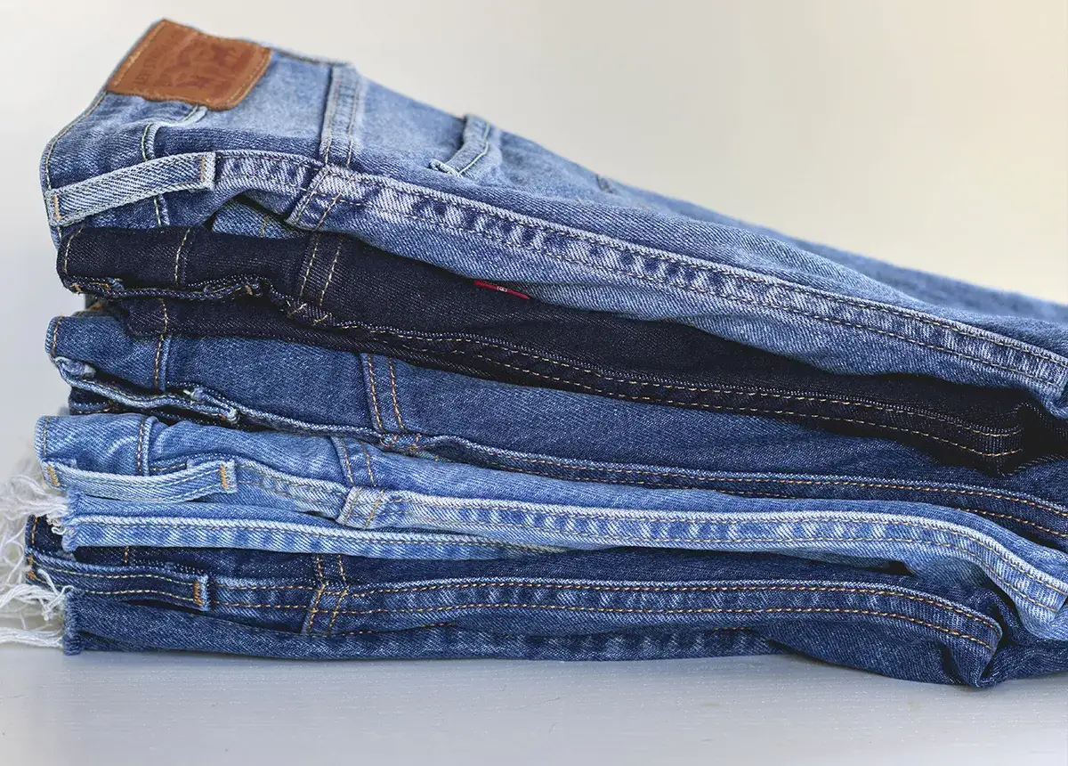 Stosik różnych odcieni jeansów, gotowych na program denim w pralce.