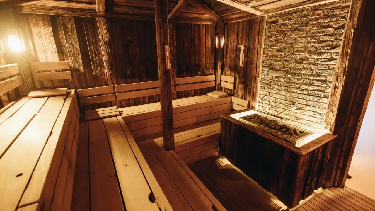 Gem&uuml;tliche Holzsauna mit mehreren Ebenen und einem Steinofen, ideal f&uuml;r Entspannung in Prag.