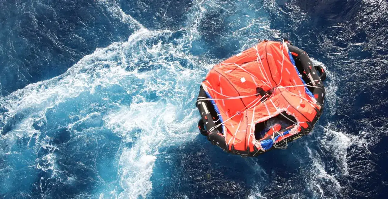 Una zattera di salvataggio arancione galleggia in mare agitato. Il suo significato &egrave; la speranza e la sopravvivenza in caso di emergenza.