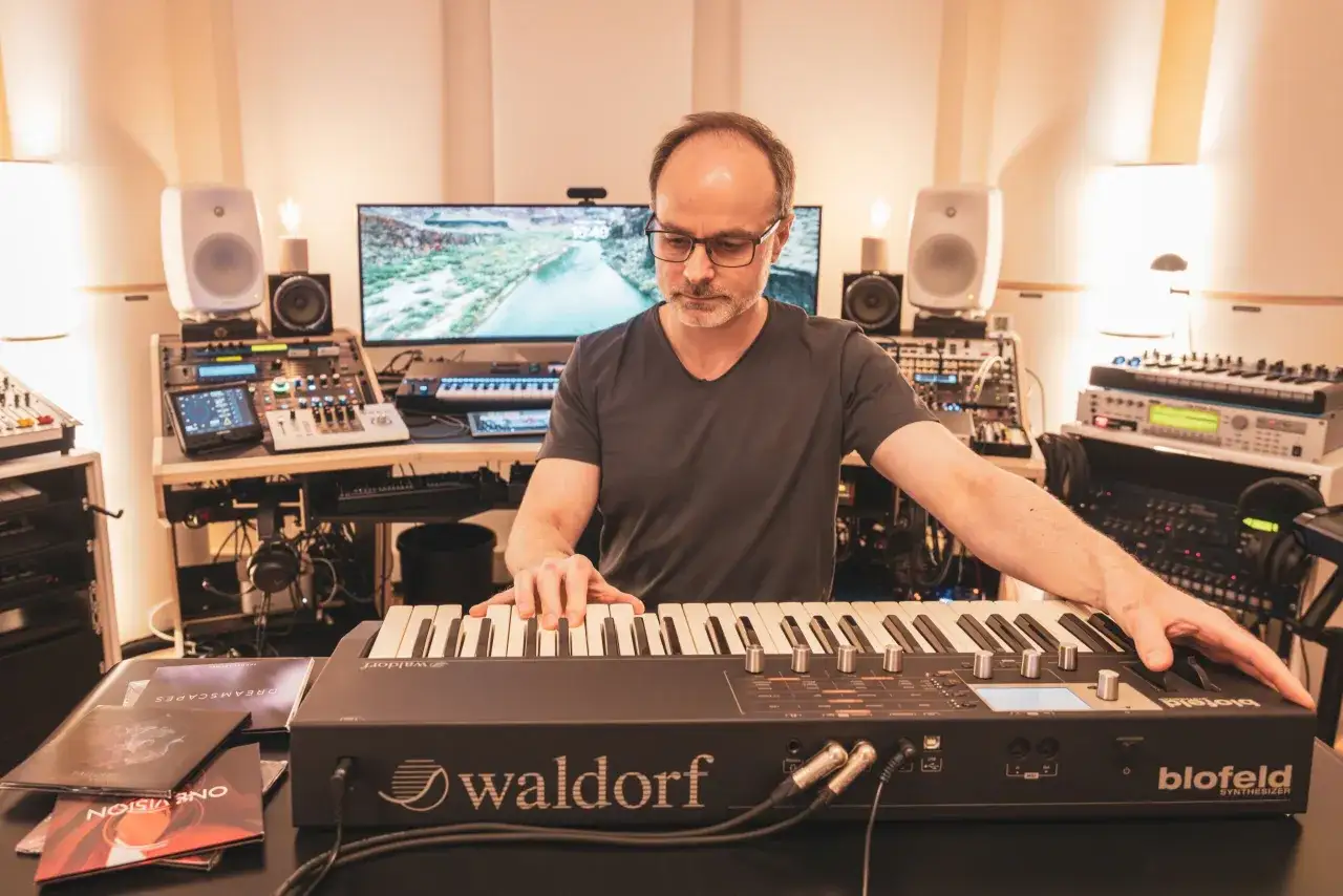 Mężczyzna tworzy muzykę ambient na syntezatorze Waldorf Blofeld w domowym studiu.