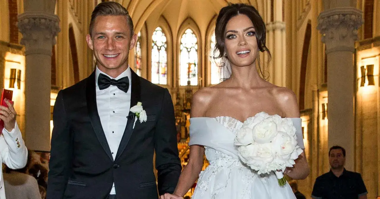 Edyta Zając i Jakub Rzeźniczak w dniu ślubu, uśmiechnięci, wychodzą z kościoła.