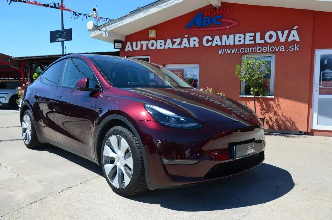 Ciemnoczerwona Tesla Model Y na placu autokomisu ABC Cambelova.