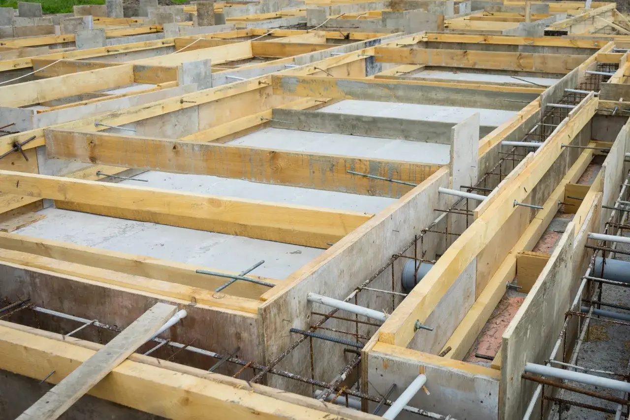 Fundament budowlany z szalunkiem i zbrojeniem. Dylatacja co to? To przerwa w konstrukcji, która pozwala na ruchy termiczne i zapobiega pękaniu.