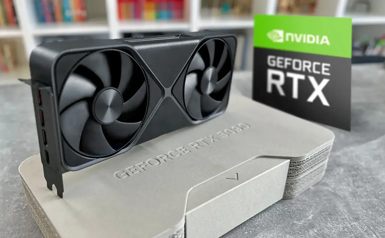 Karta graficzna GeForce RTX 3090 na szarym opakowaniu, obok zielono-czarnej tabliczki z logo NVIDIA. Idealna do gier, gdy liczy się ranking wydajności.