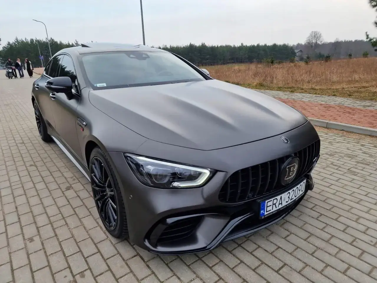 Matowy, szary Mercedes-AMG GT63S z czarnymi felgami i grillem. Zastanawiasz się nad jego mercedes amg gt63s cena?