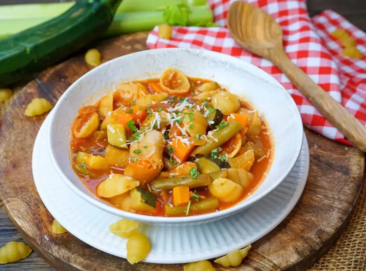 Herzhaftes Minestrone Rezept mit viel Gemüse und Pasta in einer Schüssel, garniert mit Parmesan.