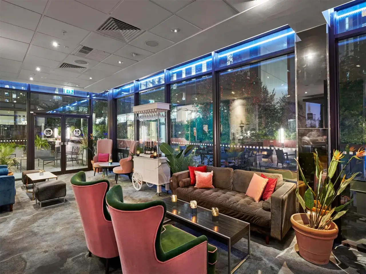 Elegancki salon hotelowy z wygodnymi fotelami i sofą, idealny na rodzinny wypoczynek. Szukasz miejsca, gdzie spać w Londynie z dziećmi? Ten hotel oferuje komfort i styl.