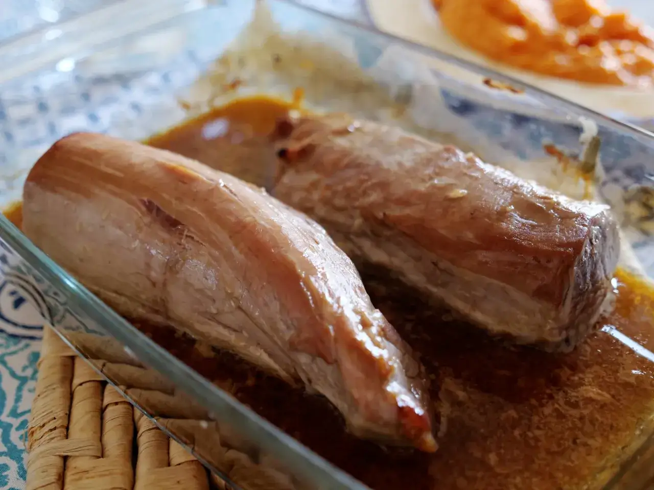 Deux filets mignons de porc dorés dans un plat en verre, nappés d'une sauce caramélisée. Parfait pour une recette filet mignon miel.
