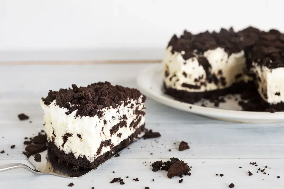 Una fetta di torta oreo cremosa e golosa, ricoperta di biscotti sbriciolati.
